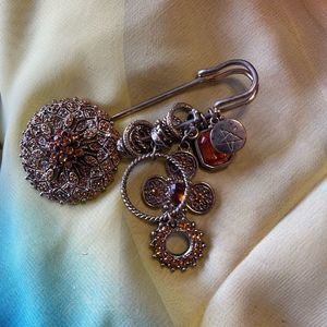 Amber brooch with charms on a clothes pin